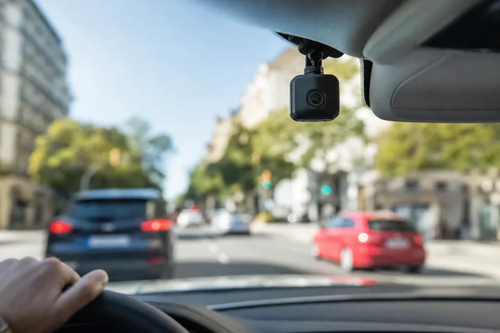 Kompakte Kamera hinter der Windschutzscheibe eines Autos, auf die Straße gerichtet, ohne lesbare Daten